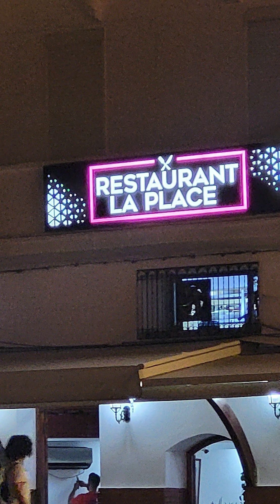 L’enseigne lumineuse « Restaurant La Place » la nuit